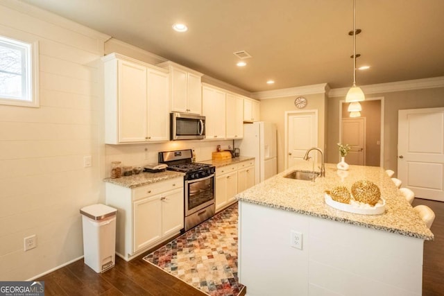 kitchen with an island with sink, light stone countertops, stainless steel appliances, and pendant lighting