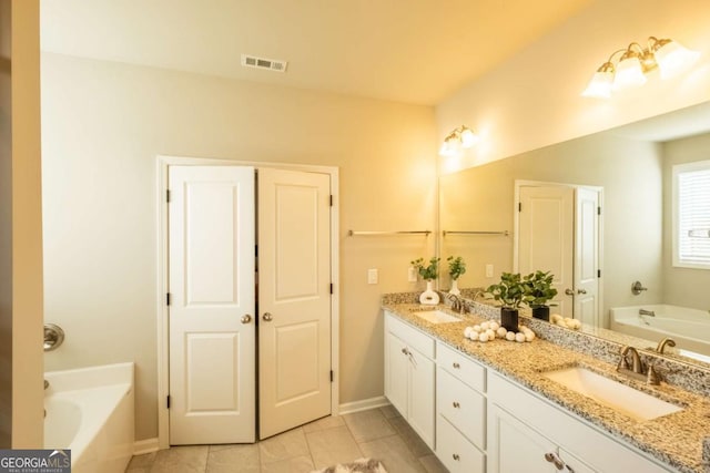 bathroom featuring a washtub, tile patterned flooring, and vanity