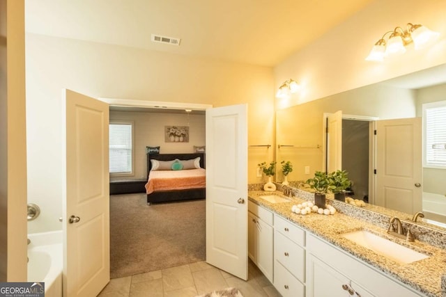 bathroom featuring vanity, a washtub, and tile patterned floors