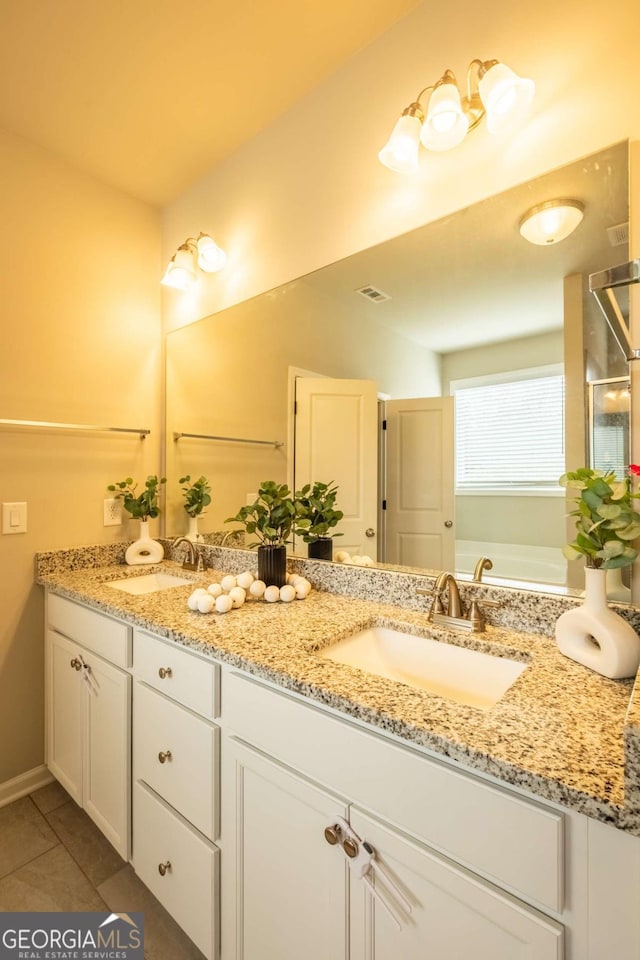 bathroom with tile patterned floors, a tub to relax in, and vanity