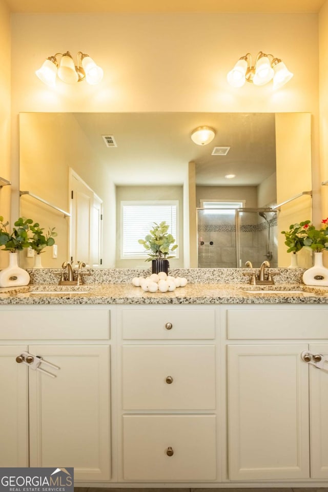 bathroom with vanity and a shower with shower door