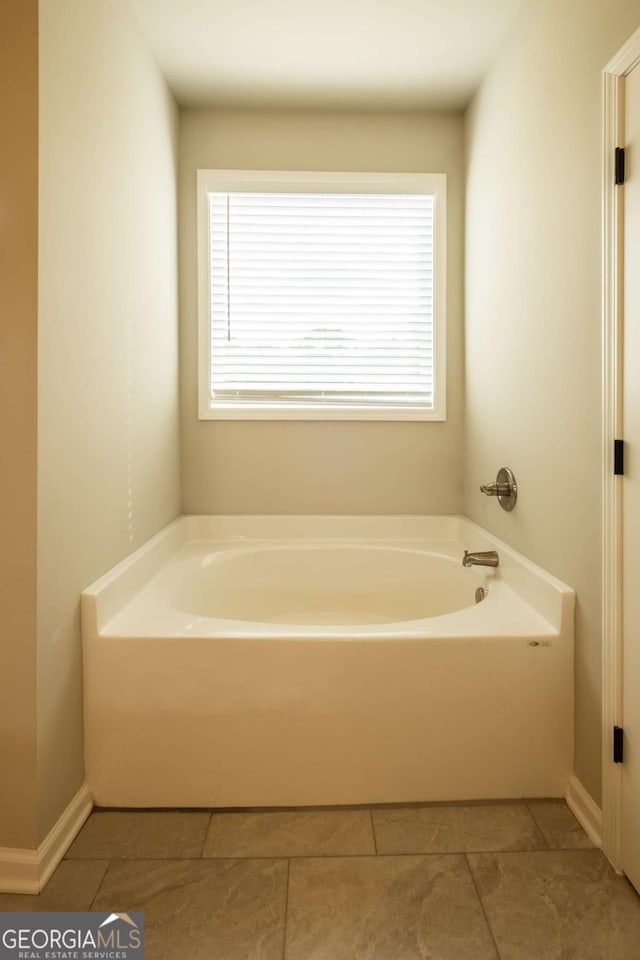 bathroom with tile patterned flooring and a washtub