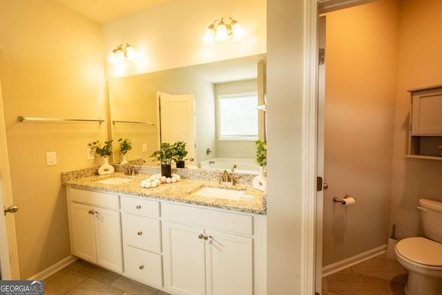 bathroom with a washtub, vanity, toilet, and tile patterned flooring