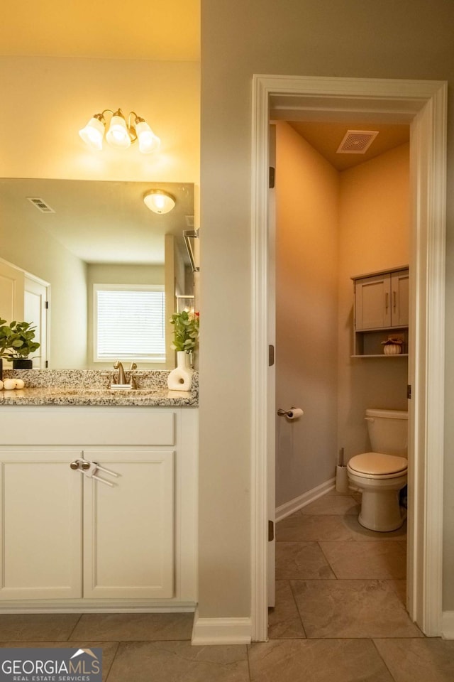 bathroom with vanity, tile patterned flooring, and toilet