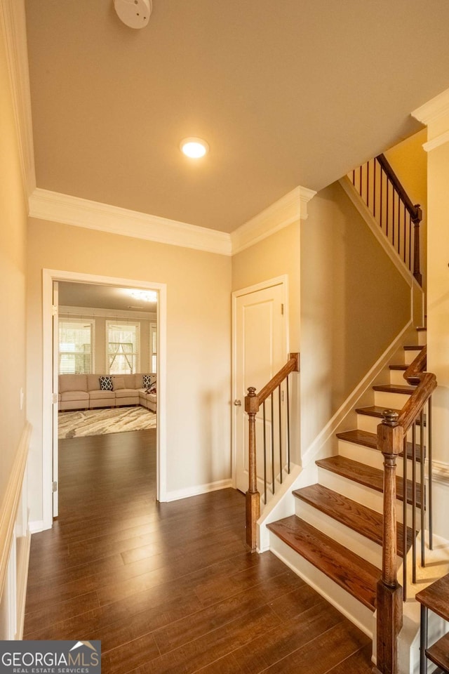 staircase with hardwood / wood-style floors and crown molding