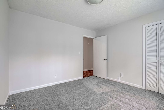 unfurnished bedroom featuring carpet floors, a textured ceiling, and a closet