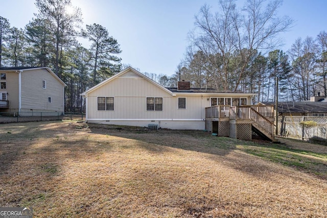 rear view of property featuring central AC, a lawn, and a wooden deck