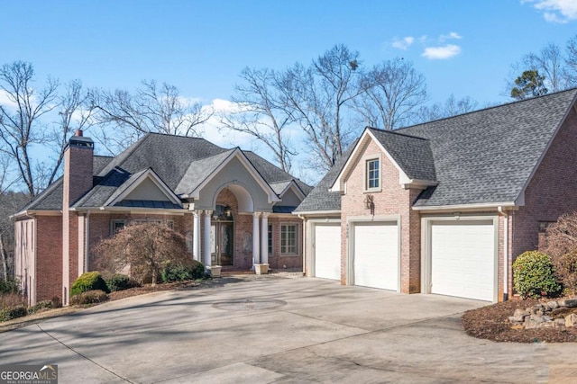 view of front facade featuring brick siding, concrete driveway, and a shingled roof