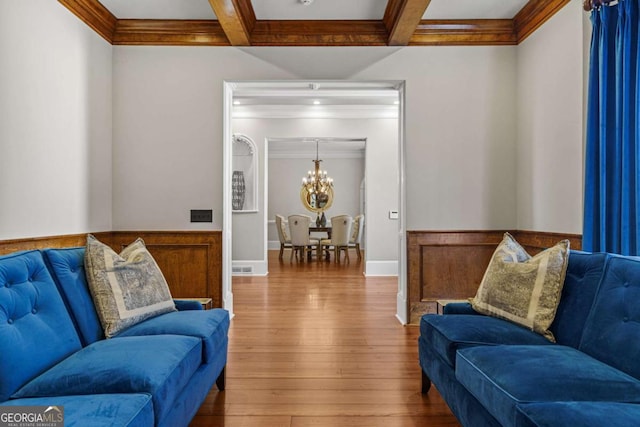 4080 Ryckeley Dr, Gainesville, GA 30504 - living room featuring a wainscoted wall, beamed ceiling, ornamental molding, hardwood / wood-style flooring, and a notable chandelier