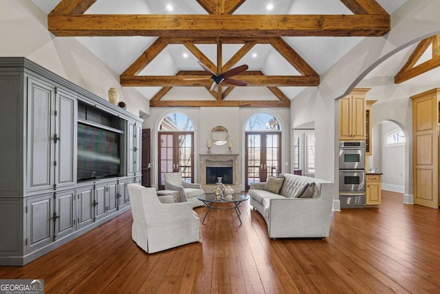 4080 Ryckeley Dr, Gainesville, GA 30504 - living area featuring dark wood finished floors, beamed ceiling, arched walkways, and high vaulted ceiling