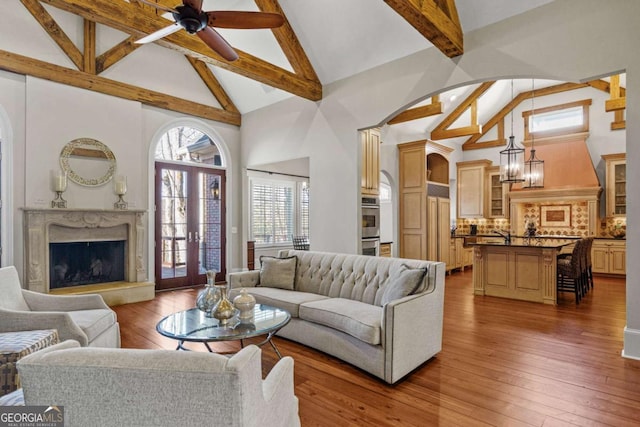 4080 Ryckeley Dr, Gainesville, GA 30504 - living area with beamed ceiling, arched walkways, high vaulted ceiling, a ceiling fan, and wood-type flooring