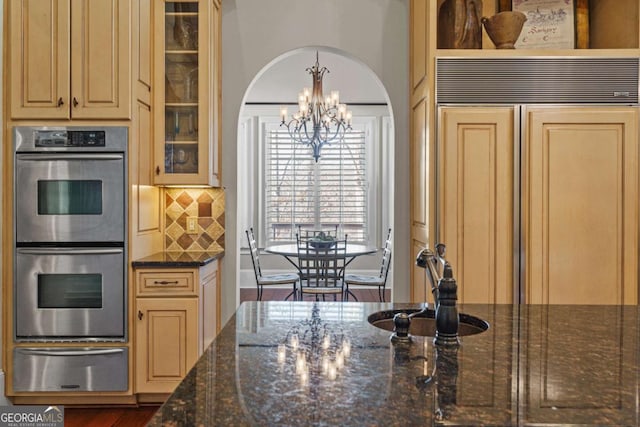 4080 Ryckeley Dr, Gainesville, GA 30504 - kitchen featuring stainless steel double oven, arched walkways, a warming drawer, a notable chandelier, and backsplash