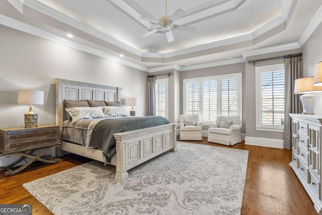 4080 Ryckeley Dr, Gainesville, GA 30504 - bedroom with a ceiling fan, baseboards, a tray ceiling, ornamental molding, and dark wood-type flooring