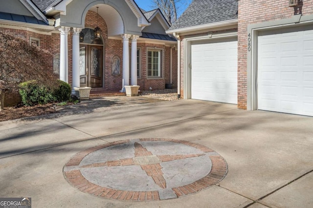 4080 Ryckeley Dr, Gainesville, GA 30504 - doorway to property with brick siding, an attached garage, roof with shingles, driveway, and a standing seam roof