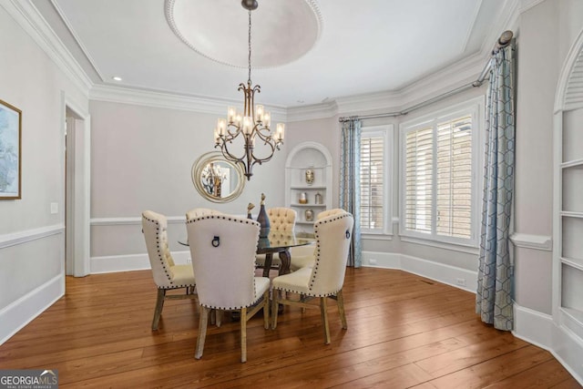 4080 Ryckeley Dr, Gainesville, GA 30504 - dining space featuring built in features, crown molding, an inviting chandelier, and hardwood / wood-style flooring