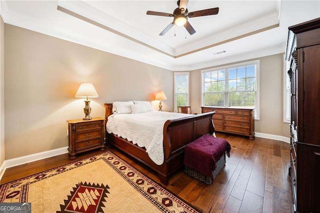 bedroom featuring a tray ceiling, dark wood finished floors, and crown molding