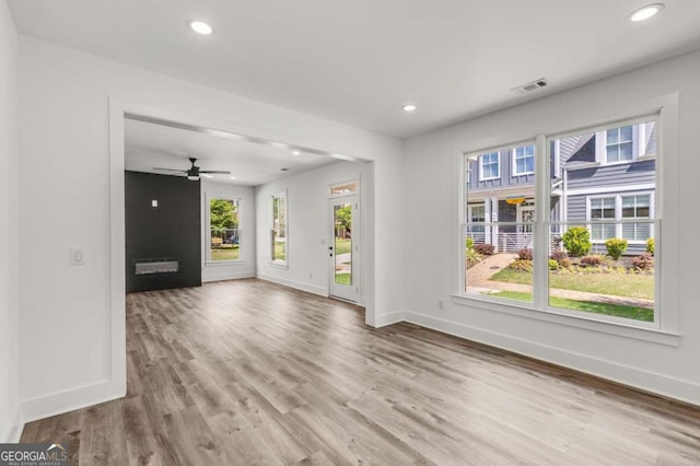 unfurnished living room with a large fireplace and wood-type flooring