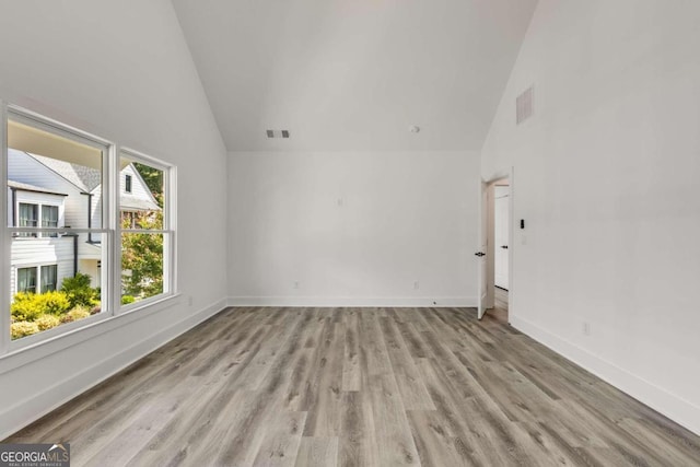 unfurnished room with light hardwood / wood-style flooring and high vaulted ceiling