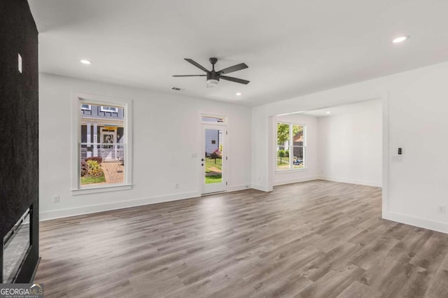 unfurnished living room with hardwood / wood-style flooring and ceiling fan