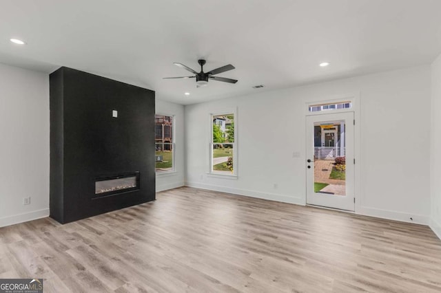 unfurnished living room with light hardwood / wood-style floors, ceiling fan, and a fireplace