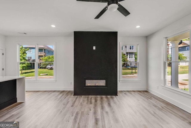 interior space featuring a large fireplace, plenty of natural light, and light hardwood / wood-style flooring