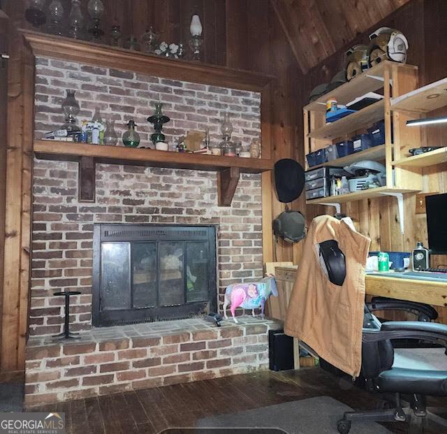 249 Ponderosa Ln, Barnesville, GA 30204 - interior space featuring a brick fireplace, wooden walls, and hardwood / wood-style floors