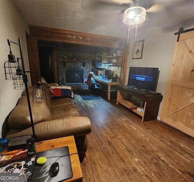 249 Ponderosa Ln, Barnesville, GA 30204 - living room featuring a brick fireplace, wood-type flooring, and a barn door