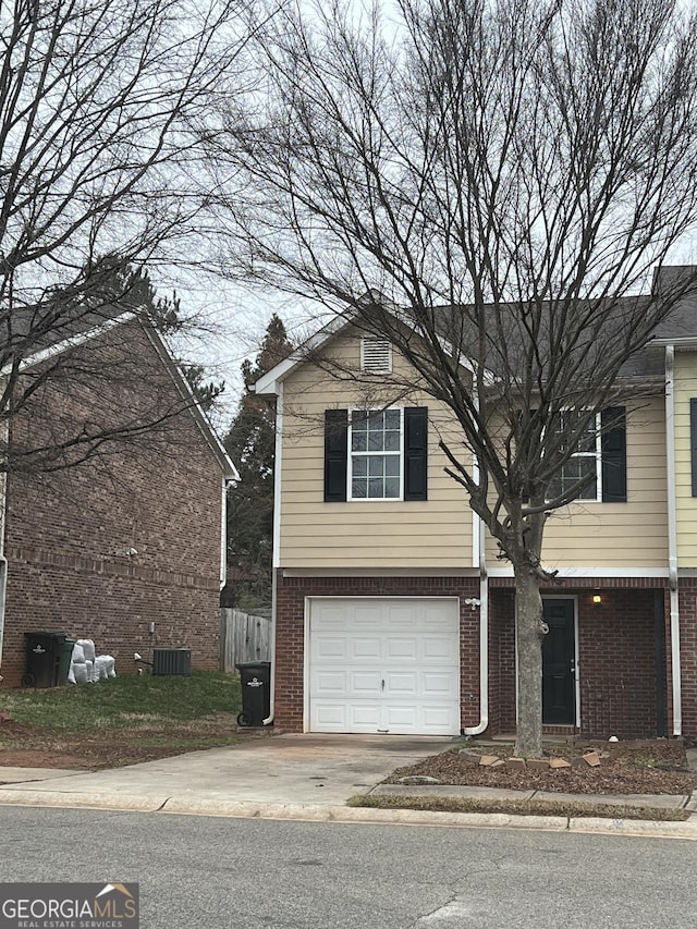 view of front of property with central AC unit and a garage