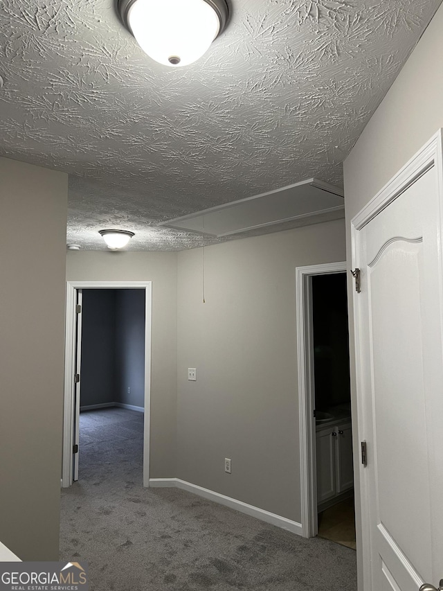 hallway featuring carpet floors and a textured ceiling