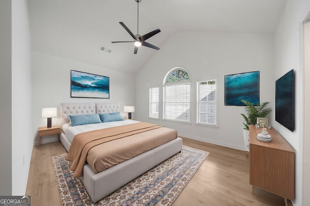 bedroom with light wood-type flooring, high vaulted ceiling, and ceiling fan