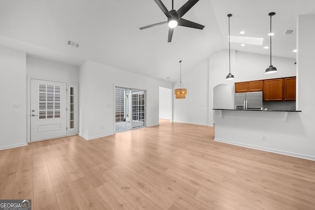 unfurnished living room with light wood-type flooring, high vaulted ceiling, and ceiling fan