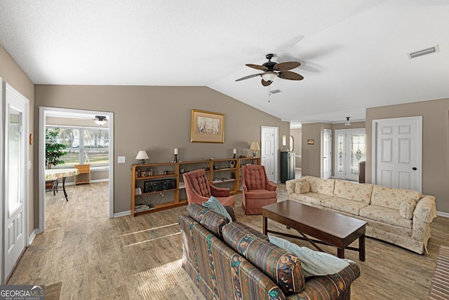 living room with vaulted ceiling, ceiling fan, and light hardwood / wood-style flooring