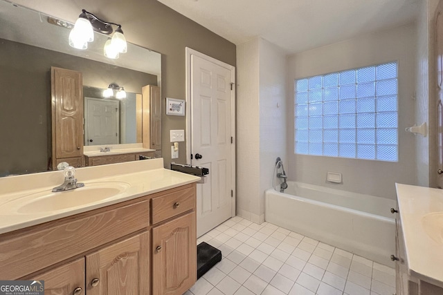 bathroom with a tub, vanity, and tile patterned floors