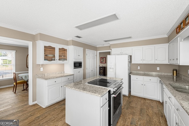 kitchen featuring electric range, a center island, white cabinetry, and built in microwave