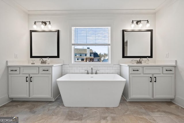 bathroom featuring crown molding, a bathtub, and vanity