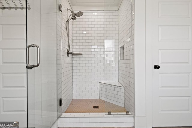 bathroom featuring a shower with door