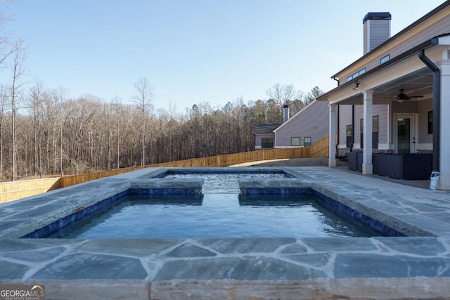 view of pool with ceiling fan and a jacuzzi