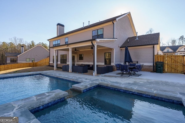 back of house featuring ceiling fan, a patio, outdoor lounge area, and a fenced in pool