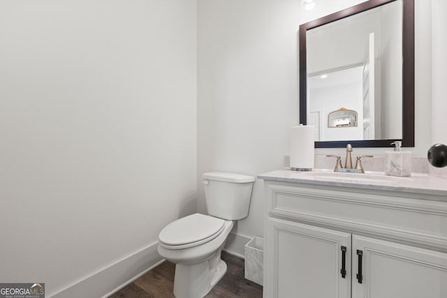 bathroom with hardwood / wood-style floors, toilet, and vanity