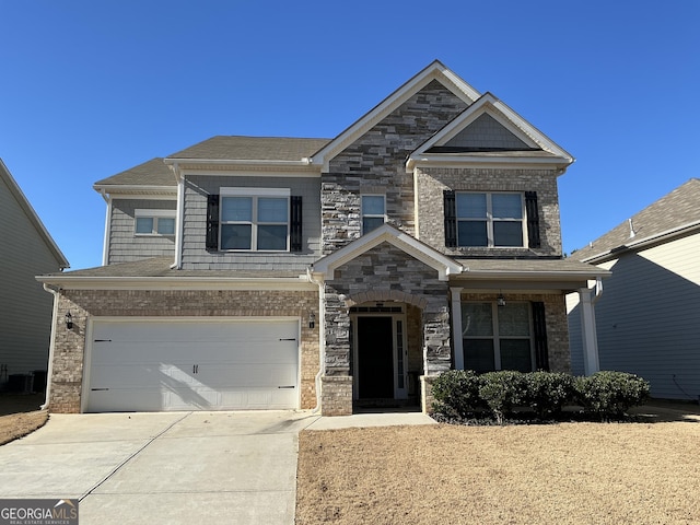 craftsman-style house featuring an attached garage, driveway, central AC unit, and stone siding