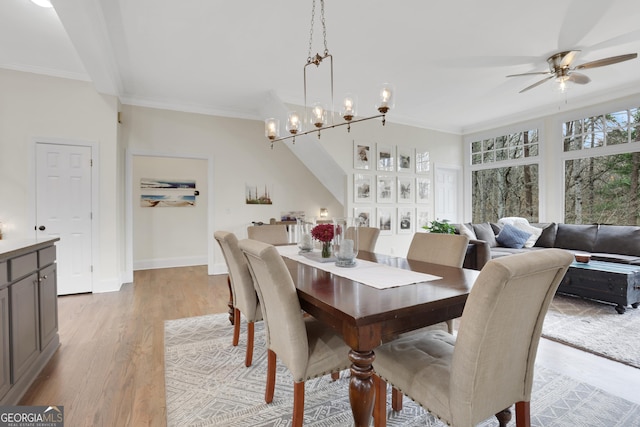 dining room with ceiling fan with notable chandelier, crown molding, and light hardwood / wood-style flooring