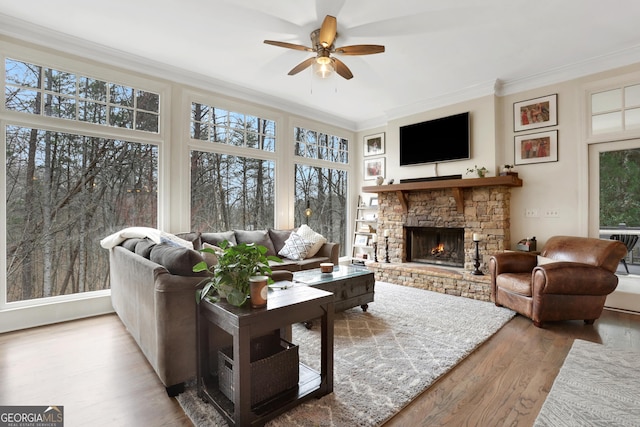 sunroom / solarium featuring ceiling fan and a fireplace