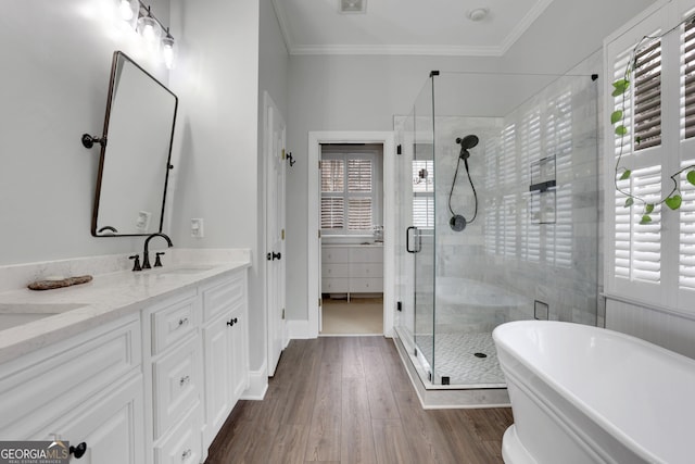 bathroom featuring hardwood / wood-style flooring, crown molding, plus walk in shower, and vanity