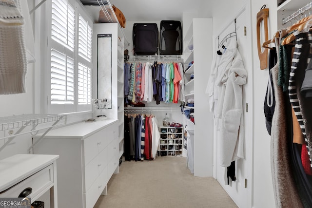 walk in closet featuring light colored carpet