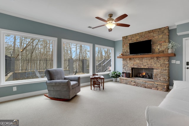 interior space featuring ceiling fan, crown molding, and a stone fireplace