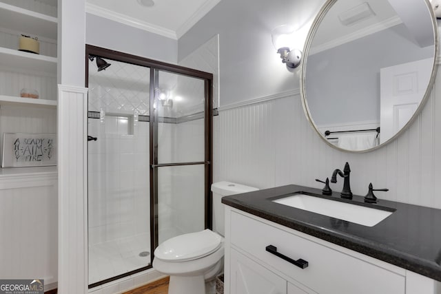 bathroom with toilet, vanity, crown molding, and a shower with door