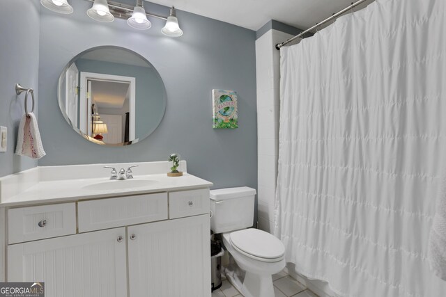 bathroom featuring a shower with curtain, tile patterned floors, vanity, and toilet