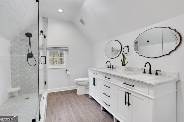 bathroom featuring toilet, wood-type flooring, lofted ceiling, an enclosed shower, and vanity