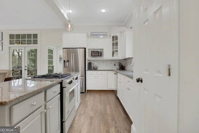 kitchen with stainless steel appliances, decorative light fixtures, light stone countertops, white cabinets, and decorative backsplash