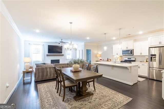 dining space featuring sink, crown molding, and dark hardwood / wood-style floors